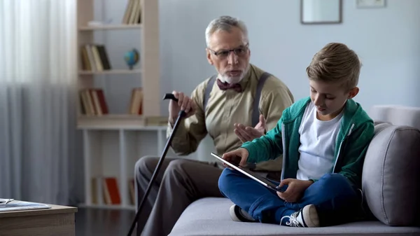 Angry Grandpa Scolding Grandson Playing Video Game Tablet Generation Gap — Stock Photo, Image