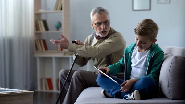 Θυμωμένος Παππούς Κατσάδα Αγόρι Για Παίξετε Παιχνίδι Βίντεο Στο Tablet — Φωτογραφία Αρχείου