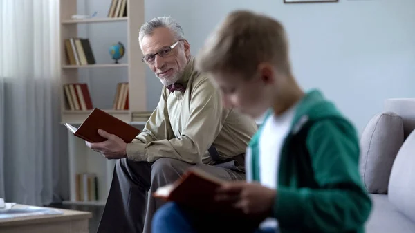 Kluger Kleiner Junge Liest Papierbuch Großvater Schaut Stolz Auf Ihn — Stockfoto