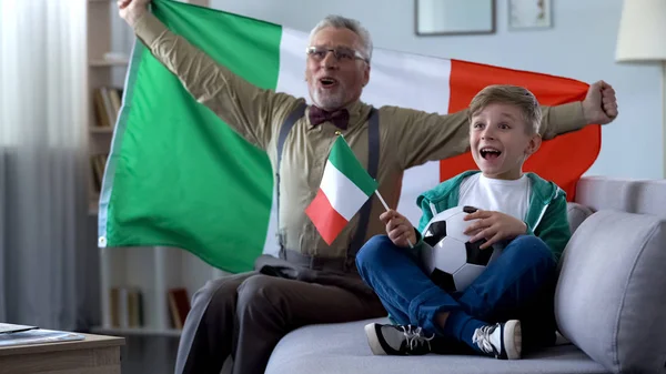 爷爷挥舞着意大利国旗 和男孩一起庆祝足球队的胜利 — 图库照片