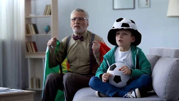 爷爷裹着葡萄牙国旗和男孩一起看足球 担心比赛 — 图库照片
