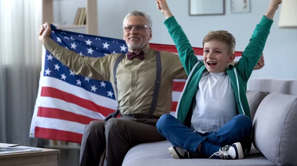 소년과 스포츠 집에서 승리에 행복을 국기를 흔들며 할아버지 — 스톡 사진