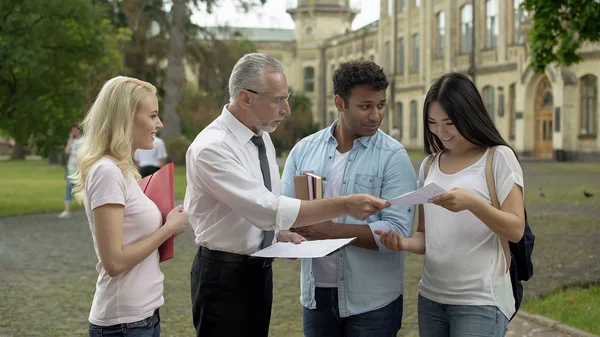 Professor Adulto Que Retorna Testes Com Marcas Para Estudantes Multi — Fotografia de Stock