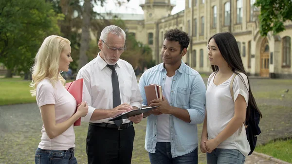 Profesor Podając Przypisania Grupy Studentów Wieloetnicznego Edukacja — Zdjęcie stockowe