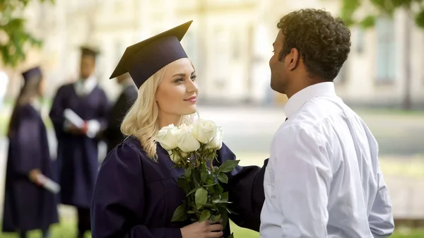 Diplômée Dans Les Regalia Académiques Avec Des Fleurs Parler Petit — Photo