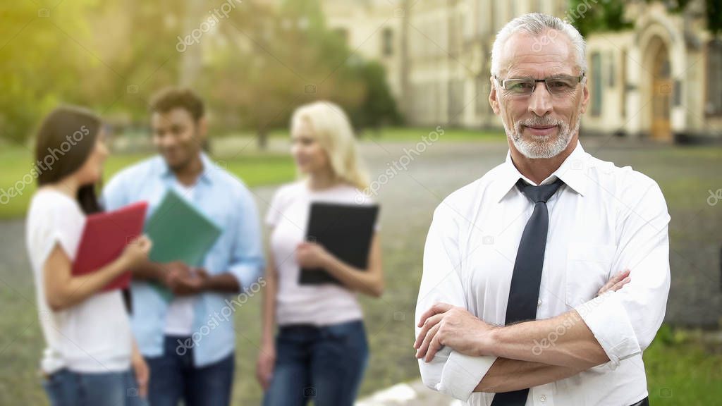 Successful professor posing with hands crossed, university education, future