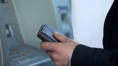Atm para çekme ve hesabını kontrol için PIN kodunu yazarak cüzdan ile adam