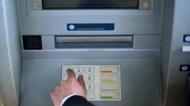 PIN kodunu Atm klavyede yazarak adam erişim banka hesabından para çekmek için