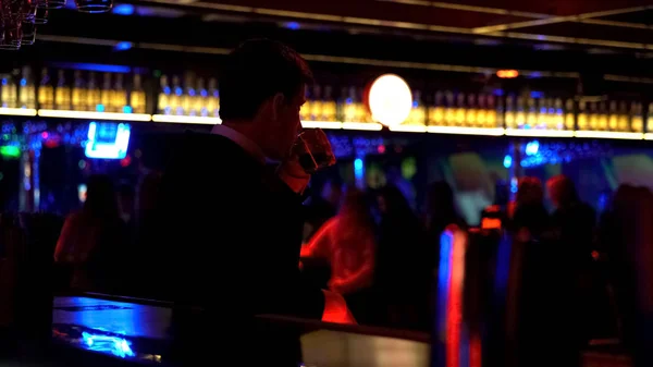 Pohledný Muž Obleku Pít Whiskey Sledování Lidí Tančí Nočním Klubu — Stock fotografie