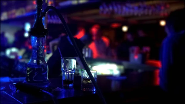 水ギセルとバーの夜のクラブ パーティーの雰囲気でカウンターに立っている つのメガネ — ストック写真