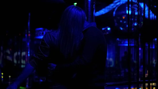 Silhouettes of loving couple hugging and kissing at night club, relaxation