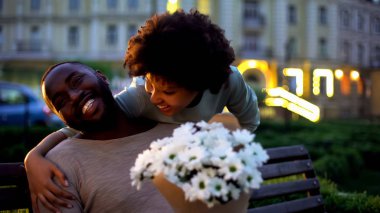 Kadın kucaklama erkek, aşk, holding çiçekler, romantik tarih arıyor