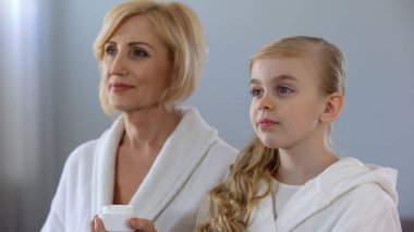 Büyükanne ve yüz kremi, geçerli olacak torun cilt bakımı, güzellik
