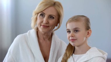 Çekici olgun anne ve küçük kızı aynaya bakmak nesiller