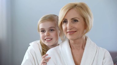 Büyükanne sarılma ve ona tarihi için hazırlamak için yardım küçük torunu