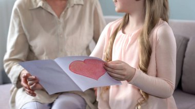 Büyükanne için el yapımı tebrik kartı sunan sevimli küçük torunum Doğum günü