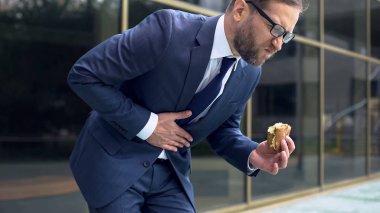 Erkek memur yemek lokanta hamburger, duygu karın ağrısı, gastrit