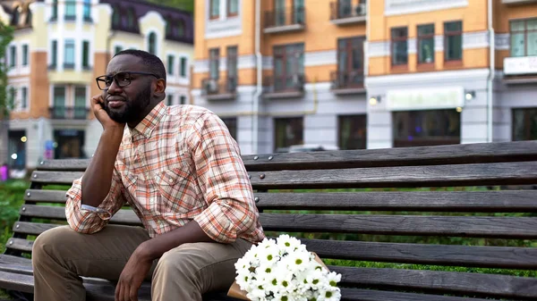 Görücü usulü, çiçekli park bankında oturan kız için bekleyen sinirli genç adam