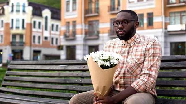 Afrikansk Mann Sitter Ensom Bybenken Holder Blomsterbukett Mislyktes Date – stockfoto