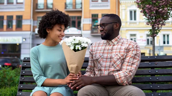 Mladý Muž Dává Bílý Květ Kytici Lavici Sedící Žena První — Stock fotografie