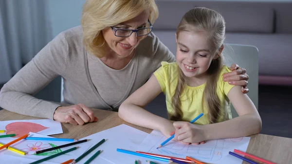 Yaşlı nine sarılma küçük torunu, güzel kız boyama evi, Aile