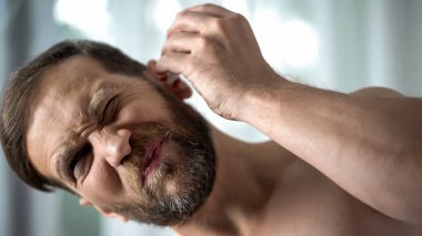 Sağlıksız erkek kulak damlayan damla, bakteriyel enfeksiyon kendi kendine tedavi, otitis