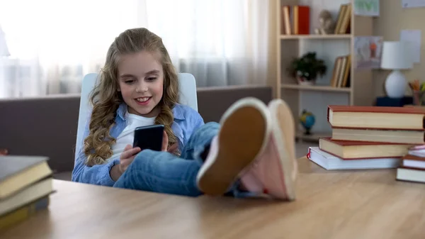 Criança Sorridente Sentada Mesa Jogando Jogo Smartphone Vício Gadgets — Fotografia de Stock