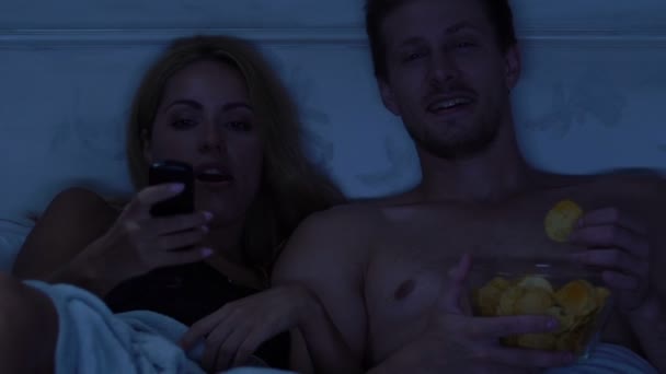 Casal Feliz Deitado Cama Comer Batatas Fritas Frente Troca Canais — Vídeo de Stock