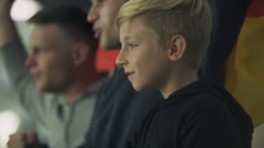 Çocuk ve yetişkin Alman futbol takımı stadyumunda tezahürat dalgalanan bayrak, fanlar