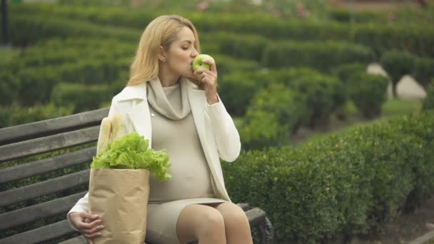 Sonriendo Esperando Dama Comiendo Manzana Fresca Banco Con Bolsa Comestibles — Vídeo de stock