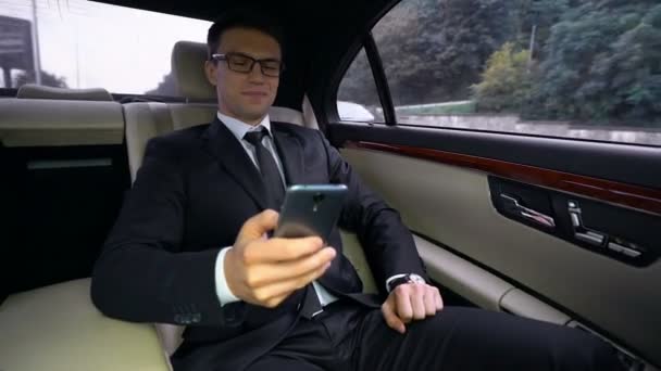 Lachende Knappe Zakenman Rijden Luxeauto Lezen Van Goed Nieuws Telefoon — Stockvideo