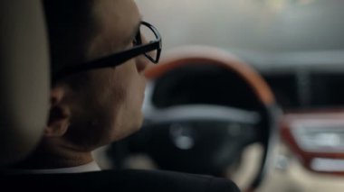 Arkadan görünüşü üzgün işadamı direksiyon simidi, delme trafik sıkışıklığı içinde bekliyor