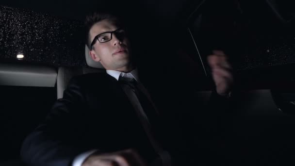 神経質なビジネスマンの仕事について心配して 車の後部座席に座っている夜間 — ストック動画