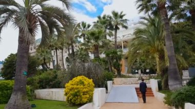 Kumarhane de Monte-Carlo, palmiye ağaçları arasında adam bahis için para ile büyük çanta taşır.
