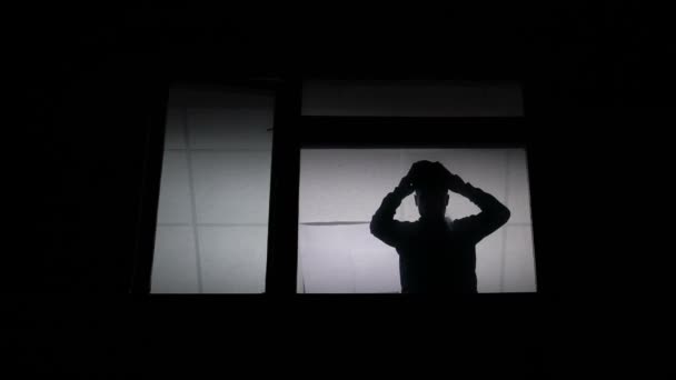 在窗口的剪影穿上巴拉克拉和离开 准备犯罪 — 图库视频影像