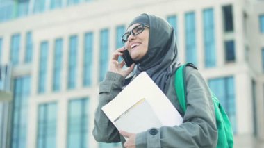 Neşeli Arapça kız öğrenci telefon ayakta Üniversitesi kampüsünde konuşurken