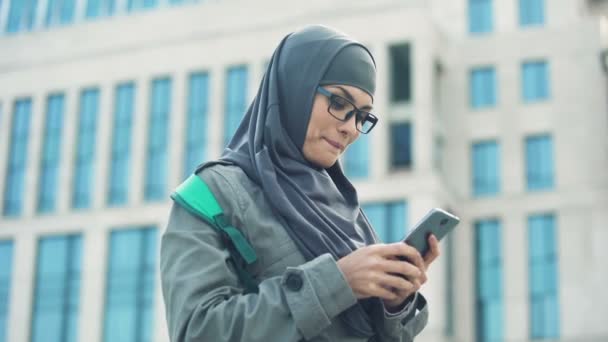 Veselá muslimských studentů chatování na telefonu, psaní e-mailů, volně komunikovat
