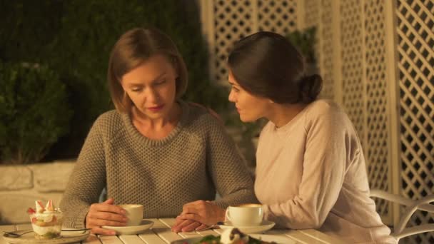 Femme Réconfortante Bouleversée Soeur Assis Dehors Sur Terrasse Boire Café — Video