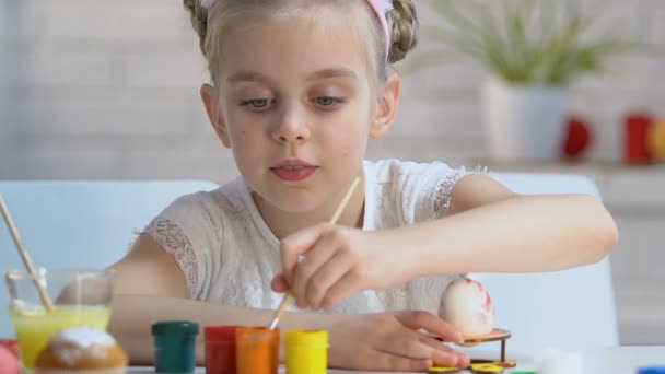 勤奋的女孩仔细地把图案与油漆在鸡蛋上 复活节装饰 — 图库视频影像