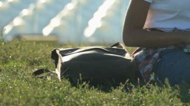 Genç kadın, Şehir Parkı, çimlere oturup dizüstü bilgisayar kullanarak rahat kıyafetler içinde dinlenmek