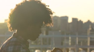 Kıvırcık saçlı genç Afro-Amerikan kadın içme suyu şehir sokak, sağlık