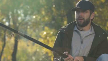 Nehir, kötü gün, zavallı catch yakınındaki yem kontrol etmek için sıkılmış erkek eğirme balıkçılık reel