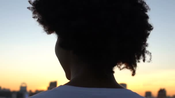 市では 残りの上に立っての夕日を楽しむ美人の背面図 — ストック動画