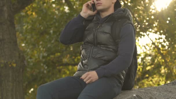 Человек Разговаривает Мобильному Телефону Сидит Вершине Большого Камня Плохая Мобильная — стоковое видео