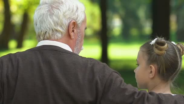 Παππούς Και Λέει Ιστορίες Κάθεται Στο Παγκάκι Στο Πάρκο Εγγόνια — Αρχείο Βίντεο