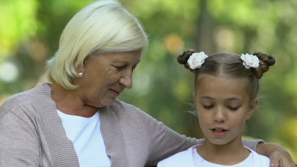 Junges Nettes Mädchen Liest Ihrem Älteren Kindermädchen Vor Sitzt Auf — Stockvideo