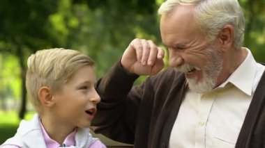 Torunu ve gülen ve having fun gün parkta birlikte zevk Büyükbaba