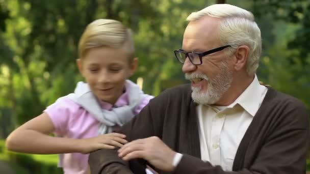 Liten Söt Pojke Sitter Bänk Nära Farfar Visar Honom Familjens — Stockvideo