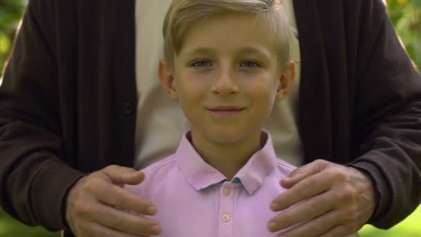 カメラ 祖父ハグ子供 信頼とケアの概念に笑みを浮かべて少年 — ストック動画