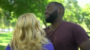 Afrikalı-Amerikalı adam kızgın hayal kırıklığına sarışın kadını sakinleştirmeye çalışıyor